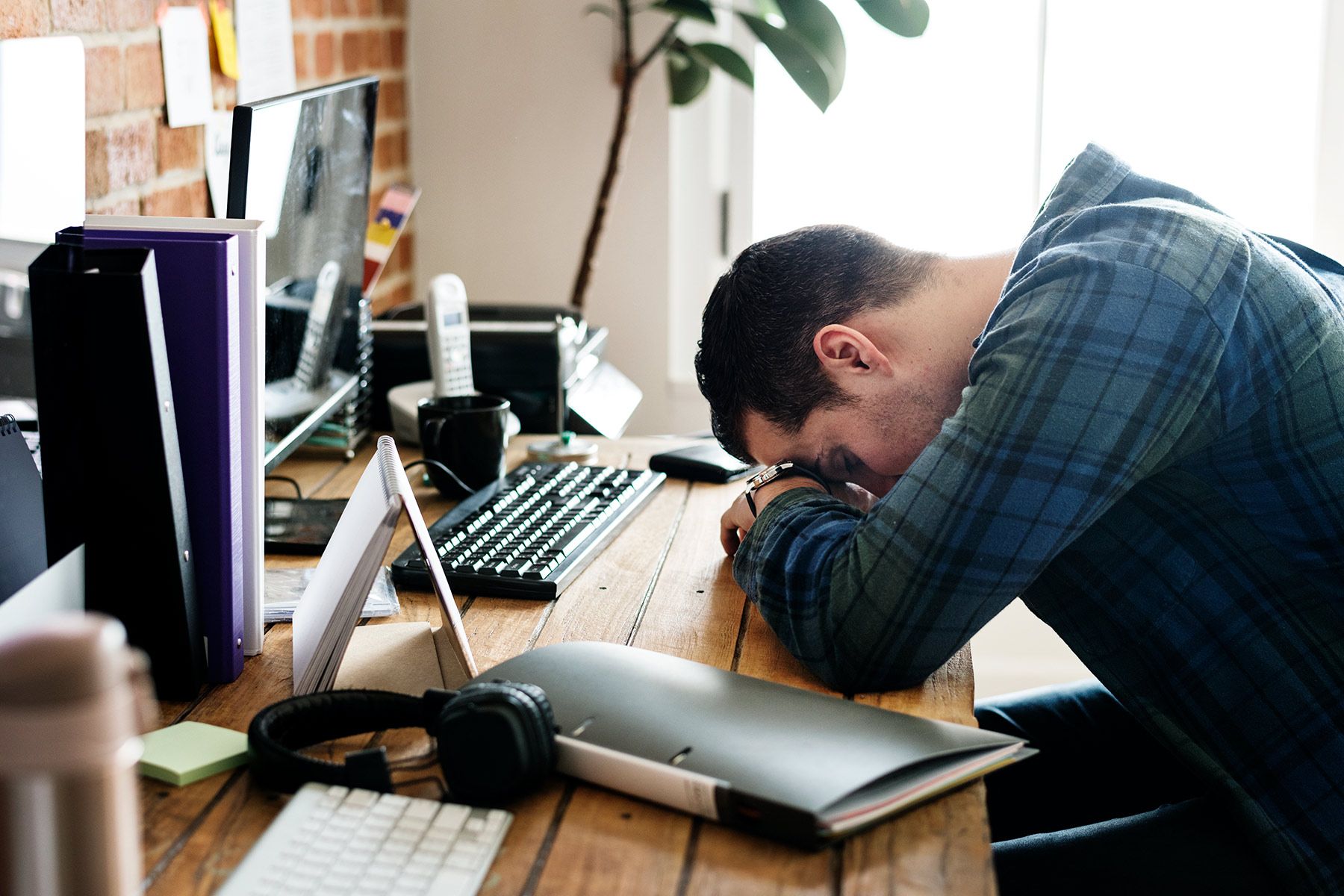 photo of tired man napping at work desk