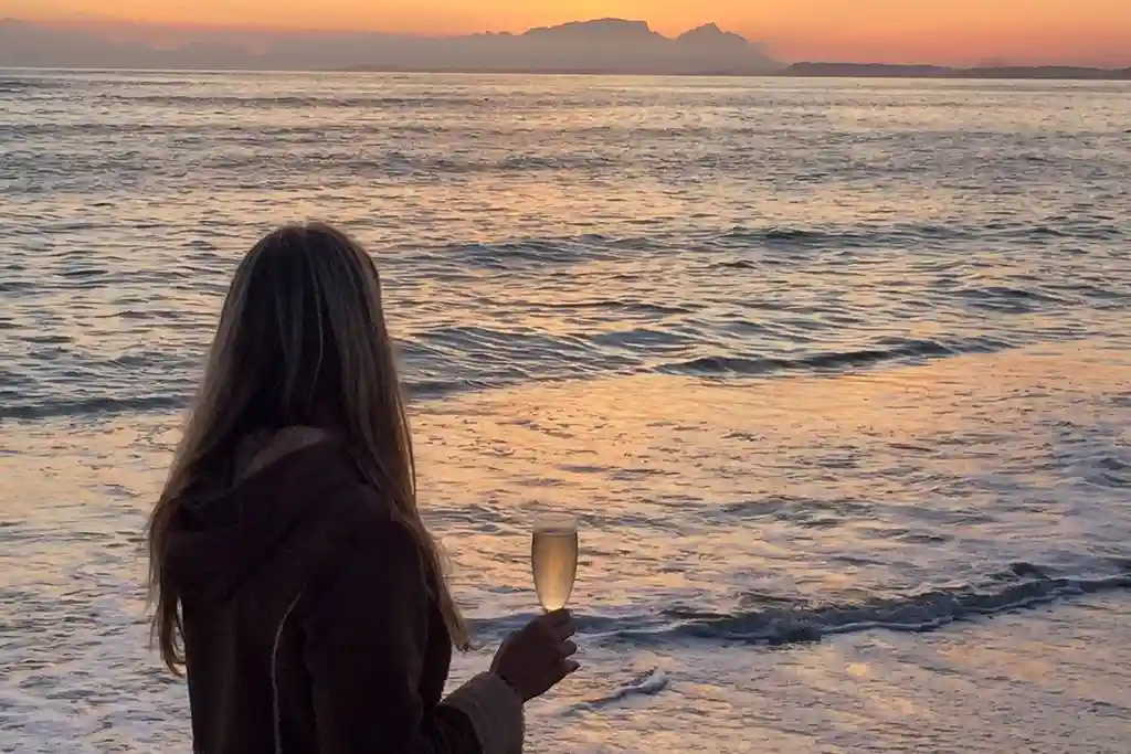 photo of woman holding champagne flute on beach