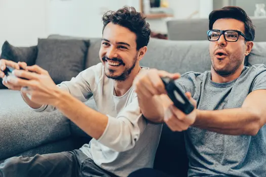 two guys playing video games at home
