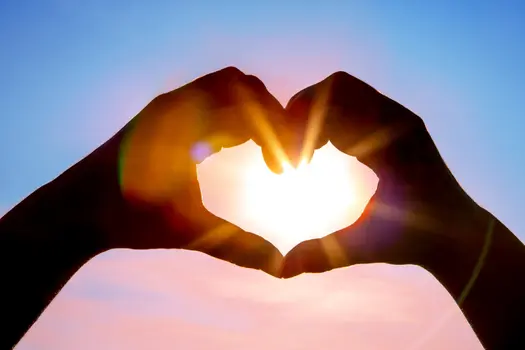 hands in shape of heart with sun