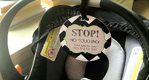 baby carry with sign that says do not touch