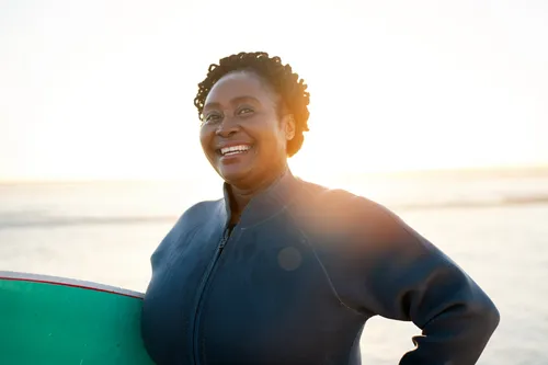 black woman with surfboard