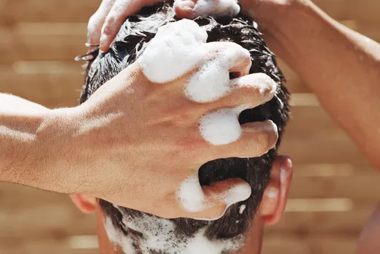 man shampooing hair