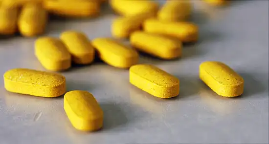 Yellow tablets spilled onto gray table top