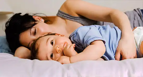Mother and son lying down on bed