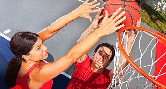man and woman playing basketball