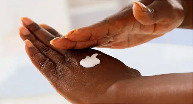 woman putting on lotion