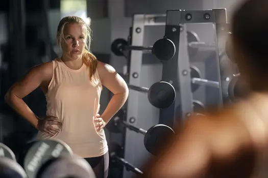 photo of woman looks at her reflection in gym