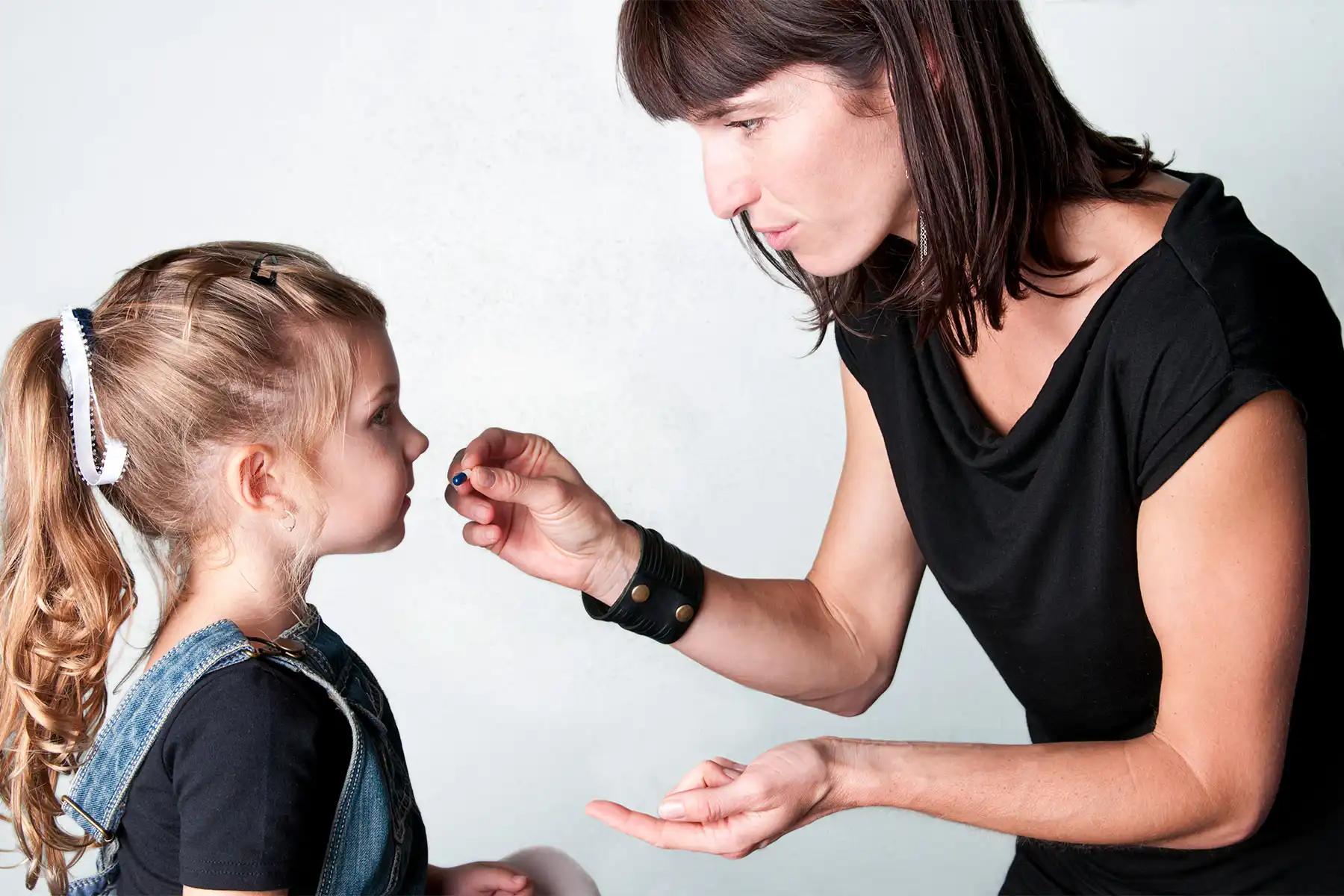 photo of mother giving pill to daughter