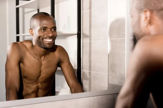 photo of happy man looking in mirror