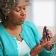 Senior woman using diabetes test kit