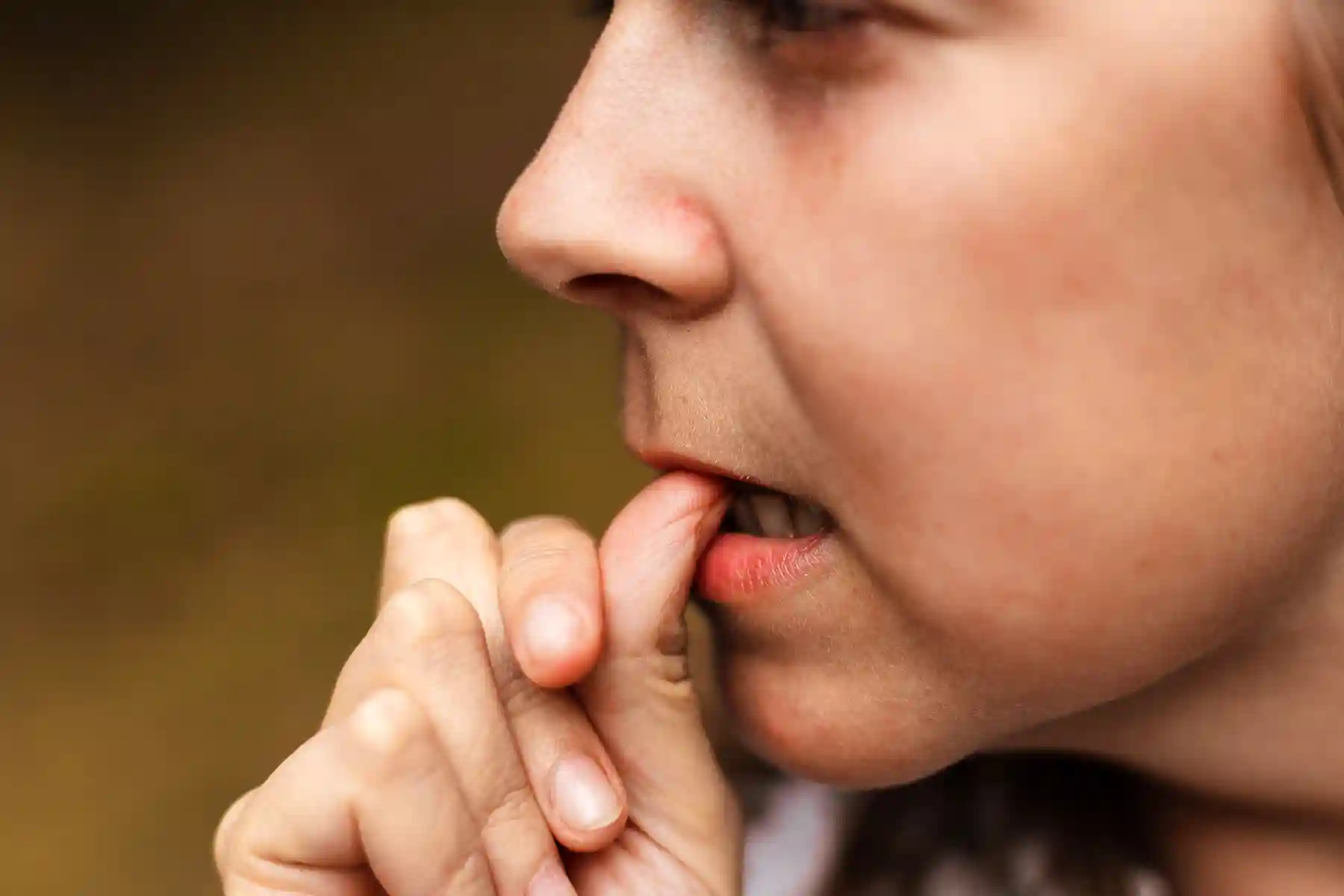 photo of anxious woman biting nails