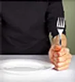 man sitting at table with fork