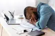 photo of African-American man sleeping at desk