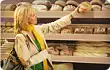 woman selecting bread in supermarket