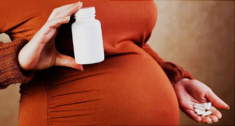 pregnant woman holidng pills