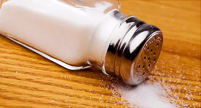 Overturned salt shaker spilling salt
