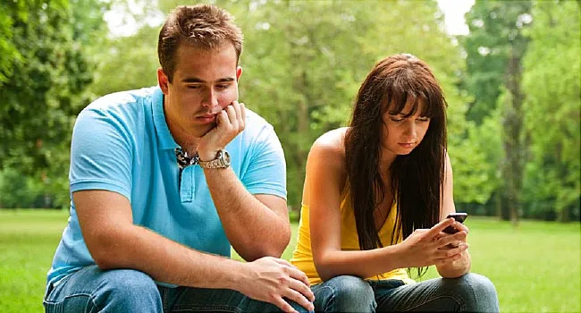 woman texting next to upset man