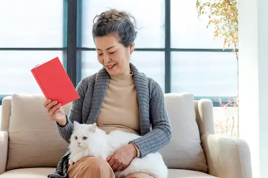 photo of woman reading alone with cat