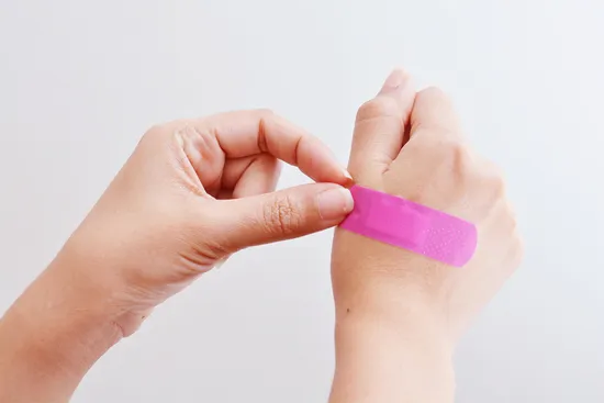 photo of medical illustration hand band aid pink