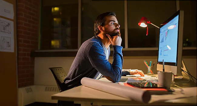 man working on computer at night