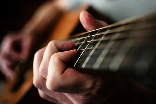 photo of man playing guitar close up