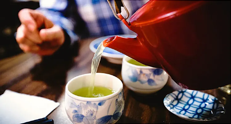 man pouring green tea