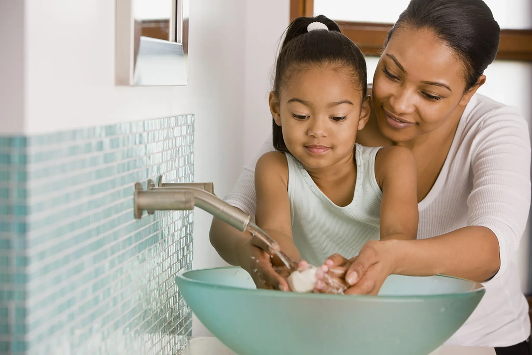 photo of mother washing daughters hands