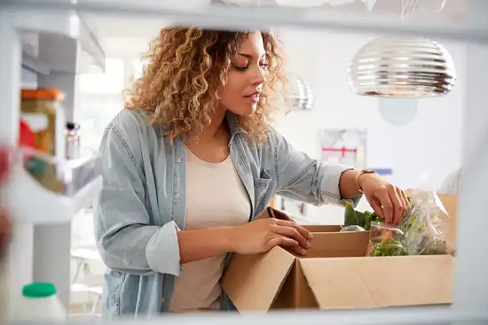 photo of woman opening box of groceries