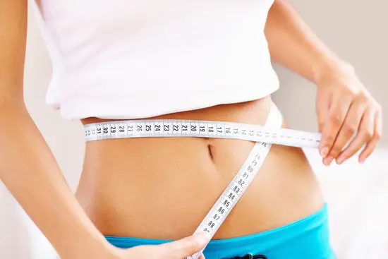 photo of woman measuring waist