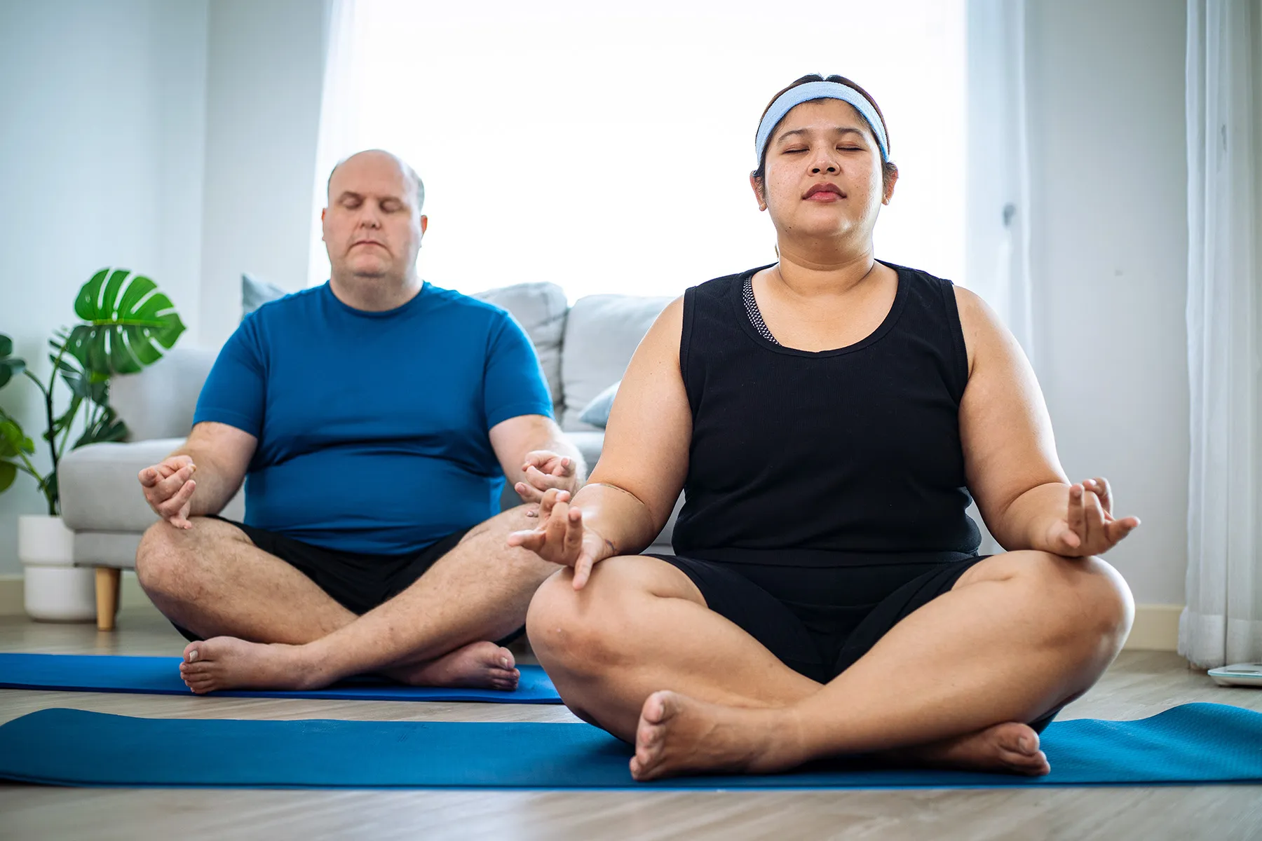 photo of overweight couple doing yoga