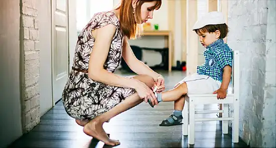mother tying sons shoe
