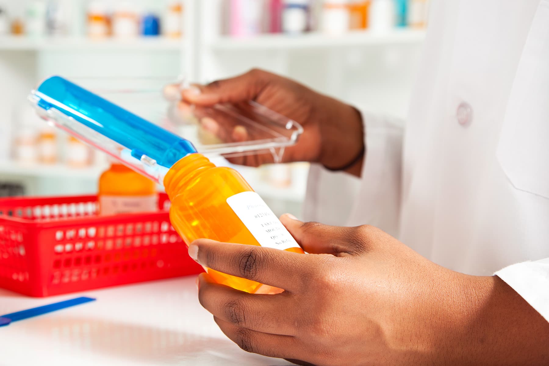 pharmacist filling prescription pill bottle