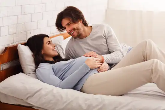 photo of pregnant couple on bed