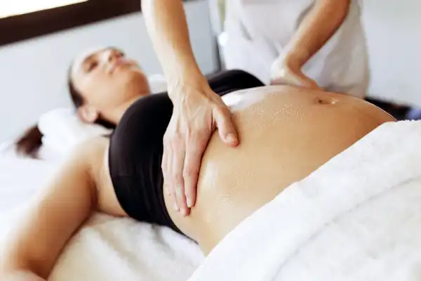 photo of pregnant woman getting massage