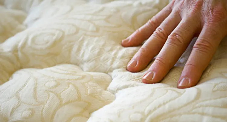 photo of hand pressing mattress