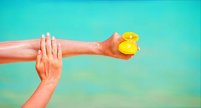 woman applying sunscreen to arm
