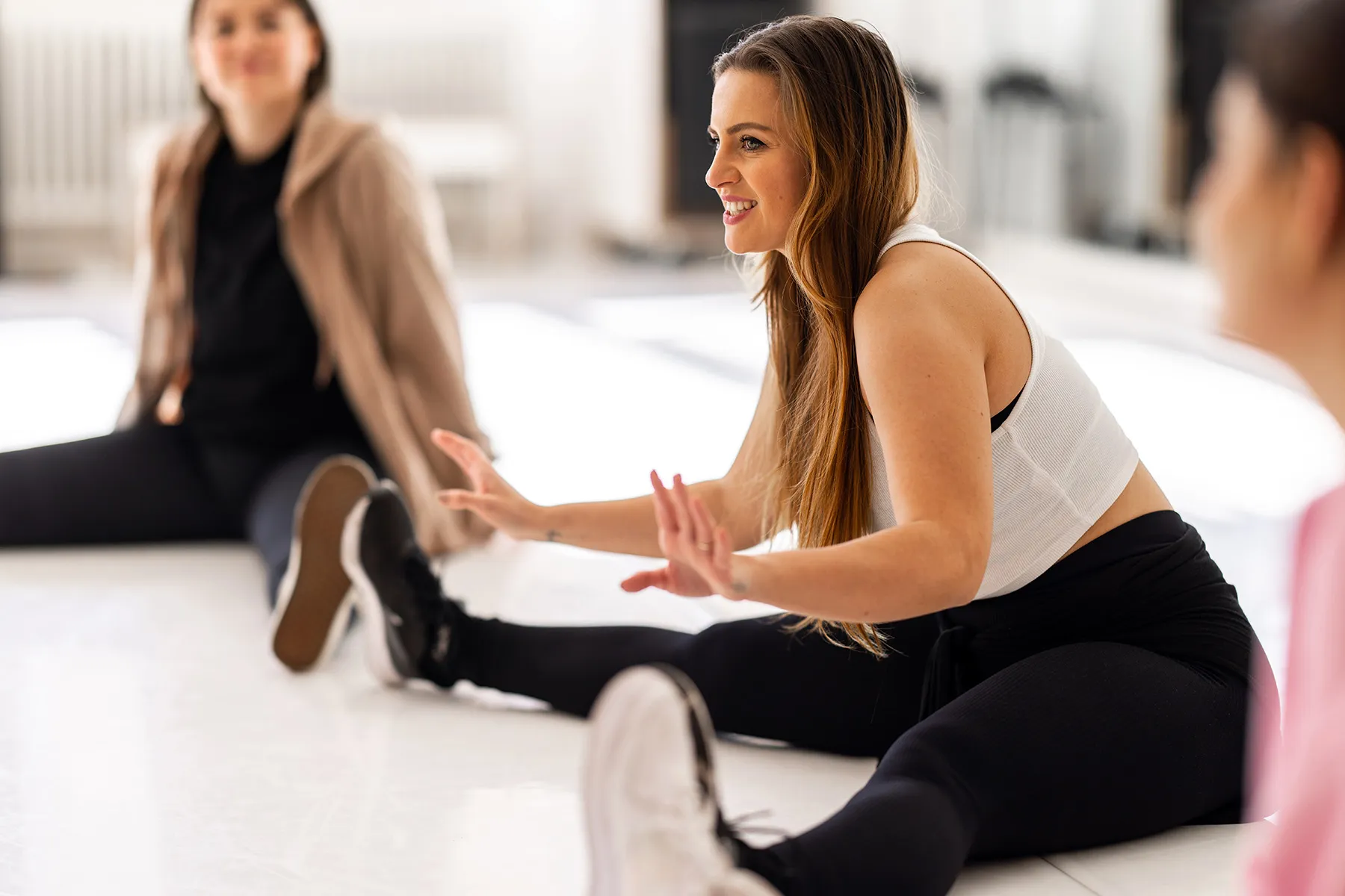 photo of woman leading stretching class in gym