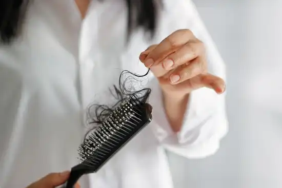 photo of woman losing hair in hairbrush