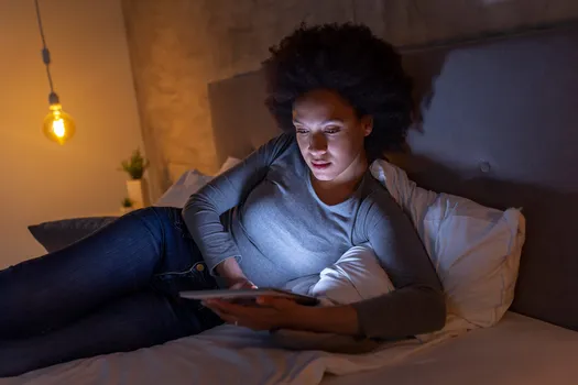 woman on bed using tablet computer