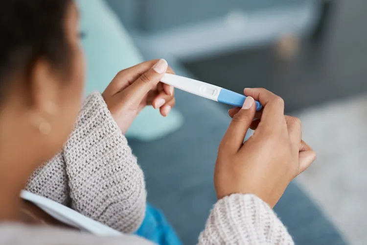 photo of woman taking pregnancy test