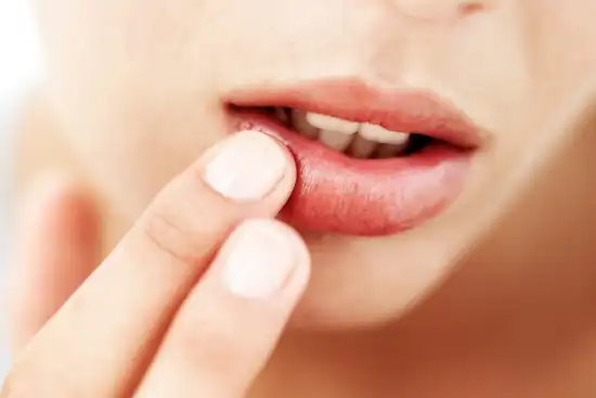 photo of woman's hand touching her lip close up