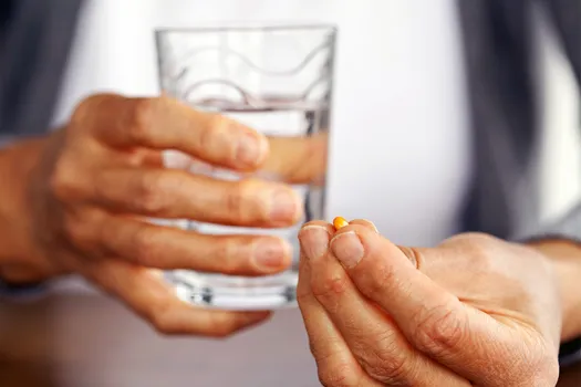 photo of woman holding pill