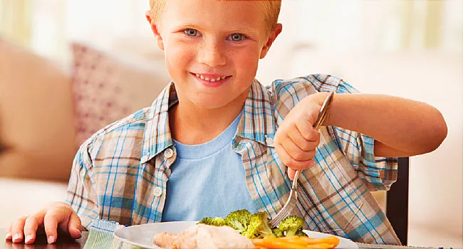 boy eating chicken and veggies