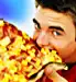 Teen boy eating huge slice of pizza