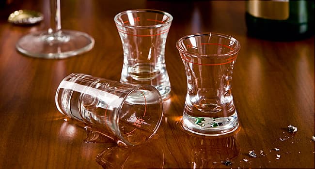 A table cluttered with shot glasses and bottles