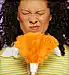 Woman holding feather duster up to face, twitching