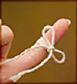 Fingertip with string tied in a bow