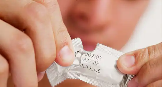 Man tearing a condom packet