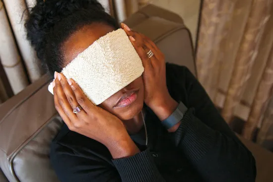 photo of woman with migraine applying compress